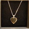 Polished gold-tone heart pendant necklace with a delicate chain made of gold-tone metal