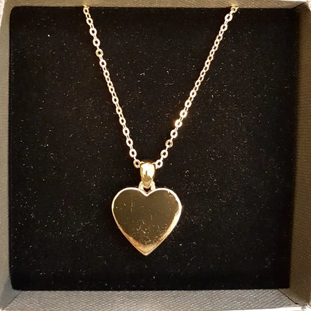 Polished gold-tone heart pendant necklace with a delicate chain made of gold-tone metal