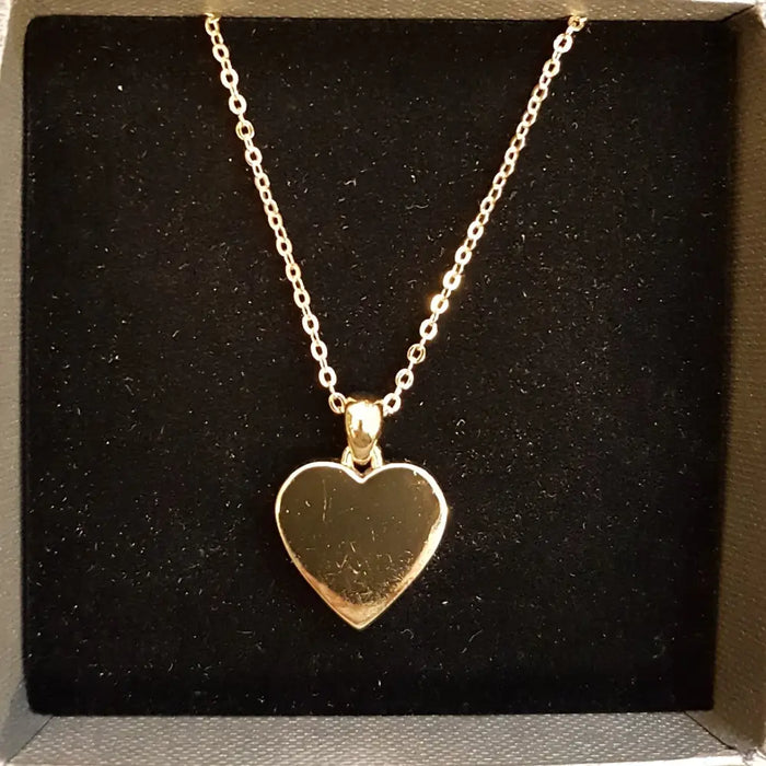 Polished gold-tone heart pendant necklace with a delicate chain made of gold-tone metal