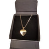 Polished gold-tone heart pendant necklace with delicate chain displayed in a black gift box