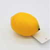 A bright yellow textured artificial fruit lemon with a small black stem and attached white tag