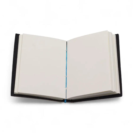 Black leather notebook with cream pages and blue thread binding in a printed leather notebook titled my chakras are aligned