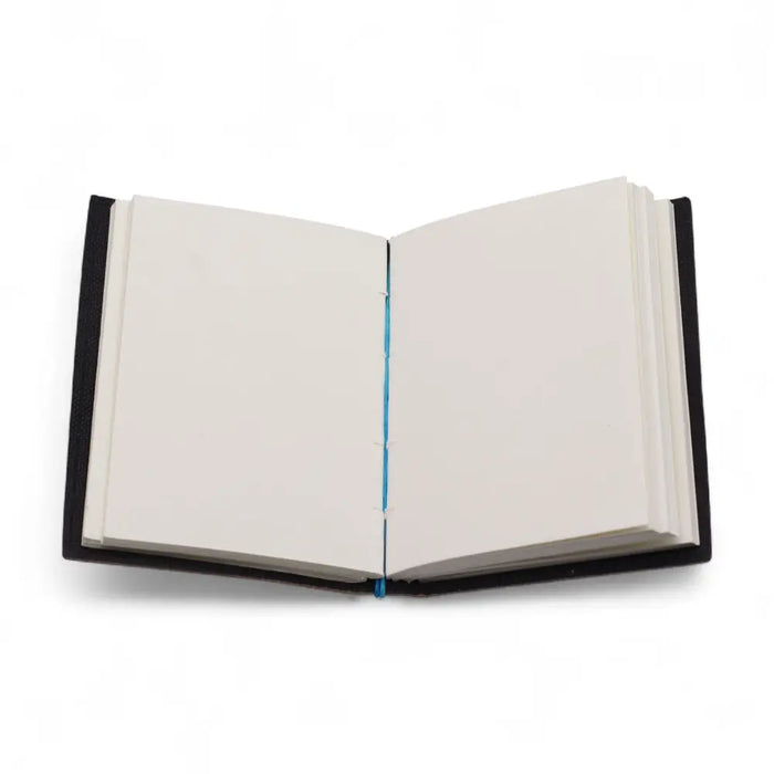 Black leather notebook with cream pages and blue thread binding in a printed leather notebook titled my chakras are aligned