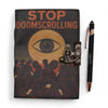 Black leather notebook with printed leather cover saying stop doomscrolling in orange with eye graphic and metal clasp