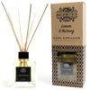 A clear glass reed diffuser with black cap filled with pale yellow lemon and nutmeg essential oils and wooden reeds