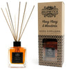 A clear glass reed diffuser with amber essential oils and light brown wooden reeds in a black capped bottle