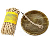 A bundle of beige himalayan cedar incense ropes with a yellow label and a twisted stick in a green marble ash bowl