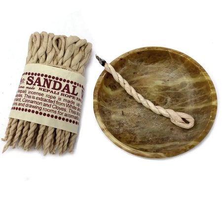 Beige twisted sandalwood incense ropes packaged with label next to a marbled bowl for pure herbs rope incense