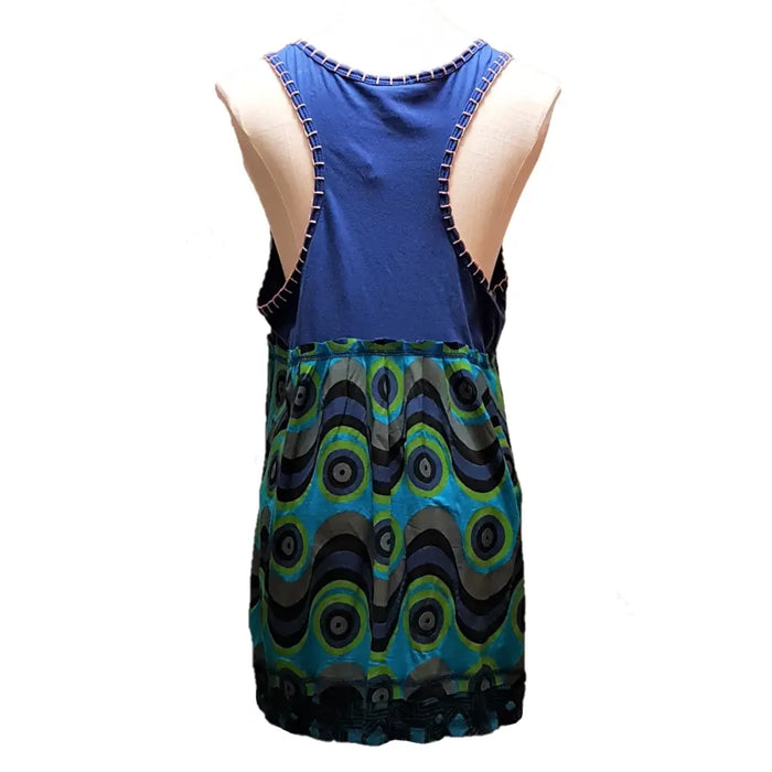 Blue and teal peacock-eye patterned sleeveless dress with dark blue straps next to purple cotton embroidered smock vest with butterfly motif