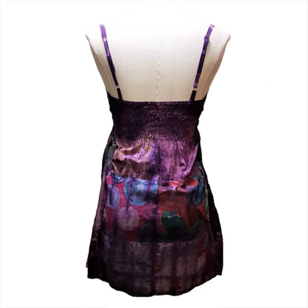 A vibrant purple tie-dyed patchwork cotton dress with spaghetti straps and a flowing skirt