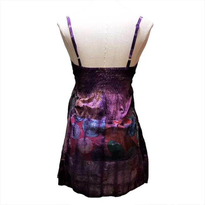 A vibrant purple tie-dyed patchwork cotton dress with spaghetti straps and a flowing skirt