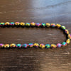 A rainbow hematite faceted bead necklace with iridescent metallic sheen and multi color reflections