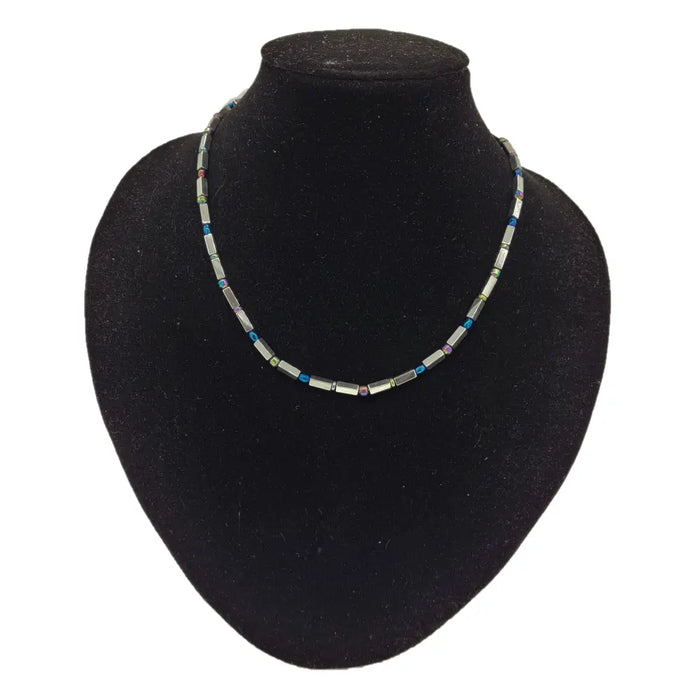 A delicate rainbow hematite peninsular necklace with silver rectangular beads and blue green purple gemstone accents