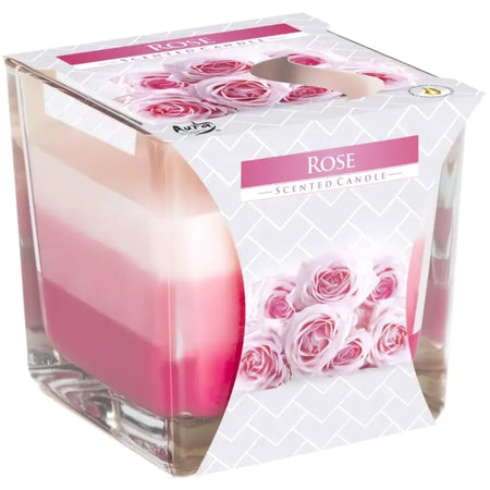 A rainbow jar candle with rose scent in a clear glass cube featuring layered pink wax and floral packaging
