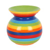 A round ceramic oil burner with vibrant concentric rainbow stripes in green yellow orange red and blue