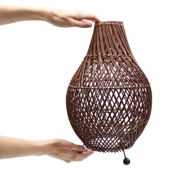 Brown woven rattan table lamp with diamond lattice design and black finial featuring natural rattan and plug fitting