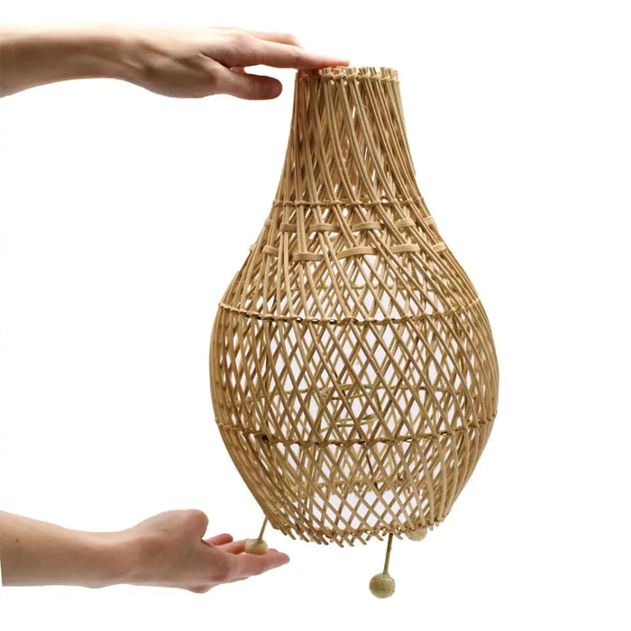 Rattan table lamp with natural beige hue handwoven from natural rattan creating delicate shadows and diamond weave pattern