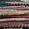 A colorful chindi rag cushion cover with red orange black white and teal recycled fabric strips in a patchwork pattern