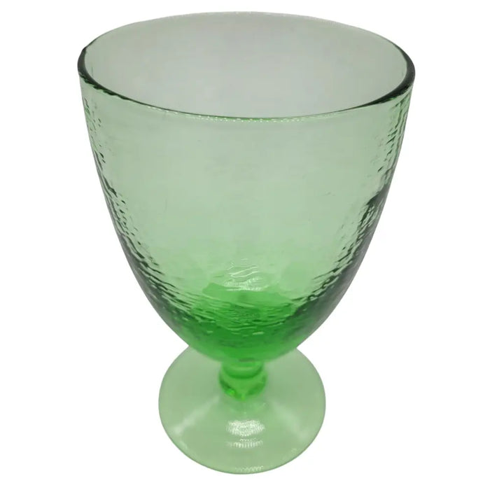 A translucent ice green recycled glass wine glass with a hammered texture and a sturdy stem
