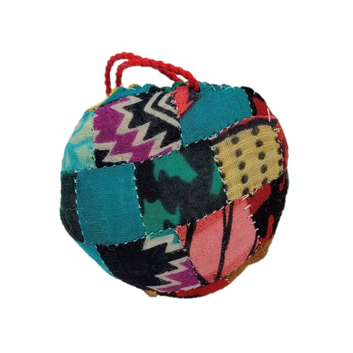 A colorful patchwork fabric ball with red rope made from recycled sari silk for hanging decorations