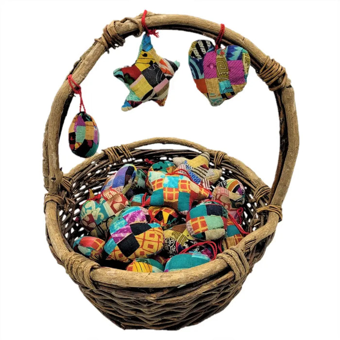Woven wicker basket filled with colorful patchwork ornaments made from recycled sari silk hanging decorations