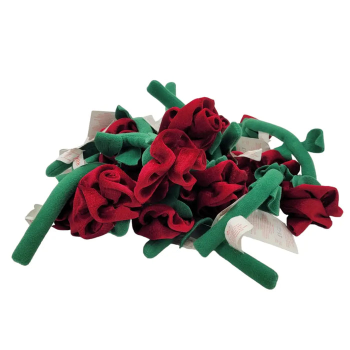 A pile of red fabric roses with ruffled petals and green stems made from soft fabric for decorative use