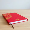 Red wellness journal with gold foil detailing and a golden mandala lotus emblem on the red hardcover cover