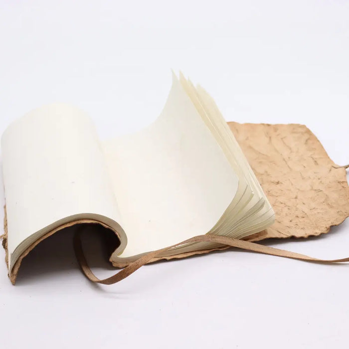 Handmade rolled leather travel notebook with textured brown leather cover cream pages and matching leather ribbon tie