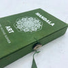 Green textured box with white mandala flower design for mandala art incense burner secured by wooden button and green string