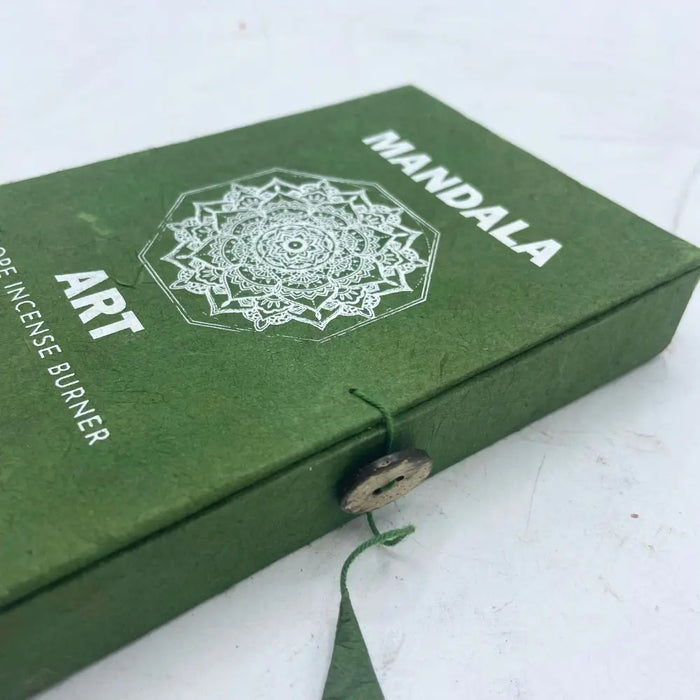 Green textured box with white mandala flower design for mandala art incense burner secured by wooden button and green string
