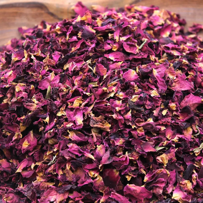 A pile of dried rose petals in deep magenta and faded yellow hues with crinkled edges weighing 0.5kg