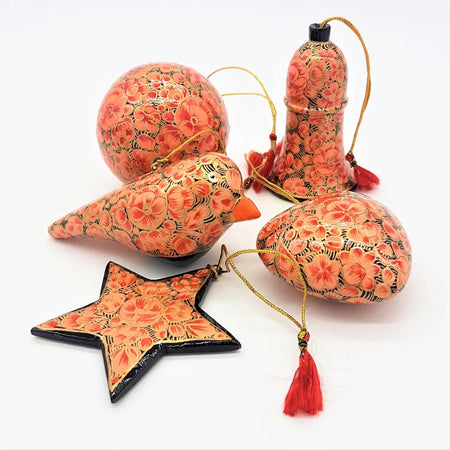 Rose pink and gold hand painted papier maché bauble with peach and black floral design and red tassels