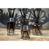Three amber round reed diffuser bottles with screw cap and black bamboo reeds in a simple setup