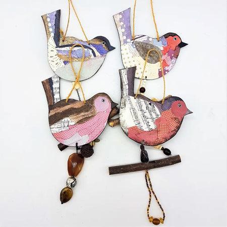 Rustic bird hanging decoration made of layered paper and wood with colorful patchwork and bead details