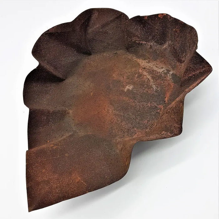 Rust-colored irregular ceramic bowl with textured surface and hammered iron leaf-like contours large dish