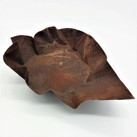 Rust-colored hammered iron leaf dish with a textured weathered surface large rustic hammered iron bowl