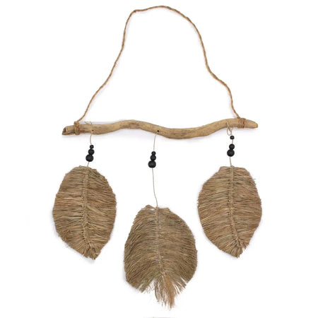 Rustic wall hanging with three natural raffia leaves on driftwood branch with black bead accents
