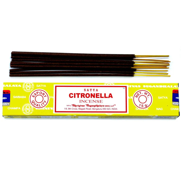 A bright yellow box of satya incense sticks with a red label and neatly arranged gold-tipped citronella incense sticks