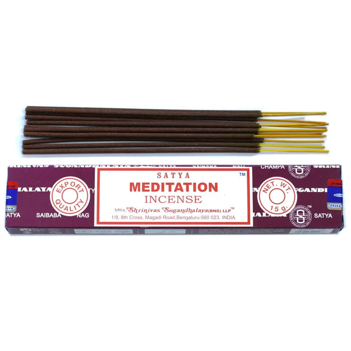 A box of satya incense sticks for meditation with a maroon white label and gold-tipped sticks arranged neatly above it