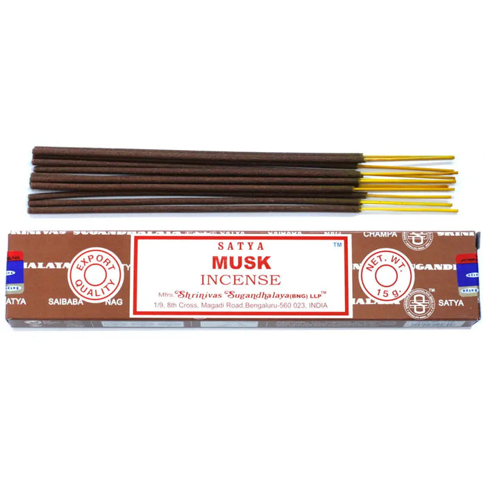 Brown satya incense sticks with golden tips in a brown cardboard box labeled satya musk incense sticks