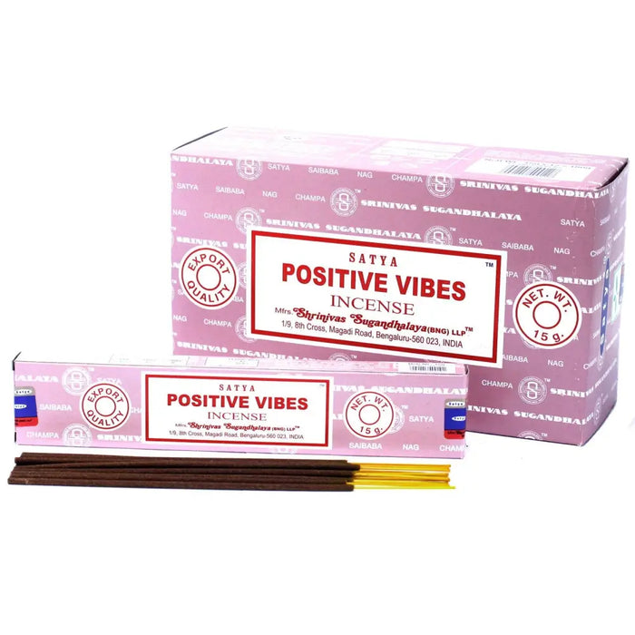 Pink cardboard box of satya incense sticks with white label red text and gold tipped wooden sticks for positive vibes