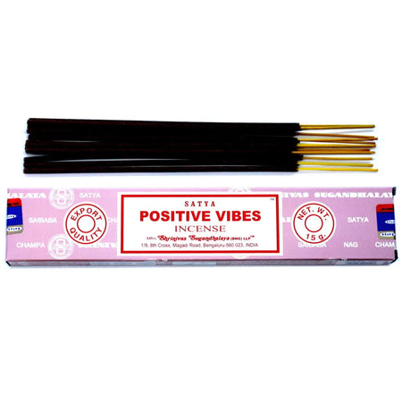 Pink rectangular box of satya incense sticks with dark brown wooden sticks and golden tips labeled positive vibes