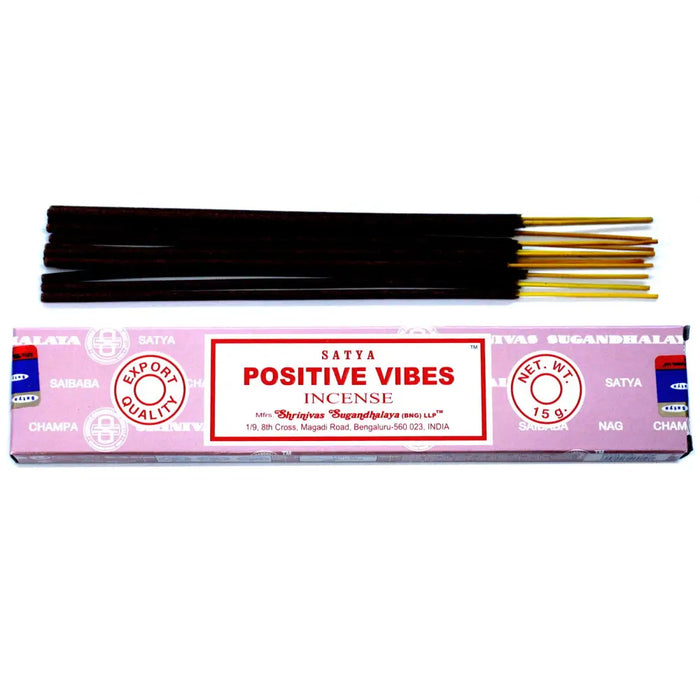 Pink rectangular box of satya incense sticks with dark brown wooden sticks and golden tips labeled positive vibes