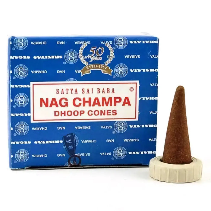 A brown satya nag champa incense cone in a white ceramic holder next to its blue nag champa branded box