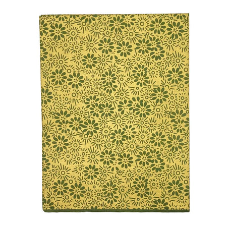 A rectangular notebook with a yellow cover and dark green floral motifs made from lokta paper gift wrap