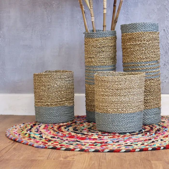 Tall cylindrical woven vases with beige and muted blue stripes made from textured seagrass and raffia rope material