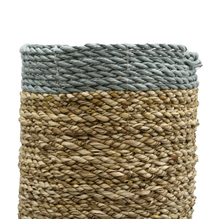A cylindrical woven vase with a gray rope rim and natural beige raffia body from the seagrass abu-abu set