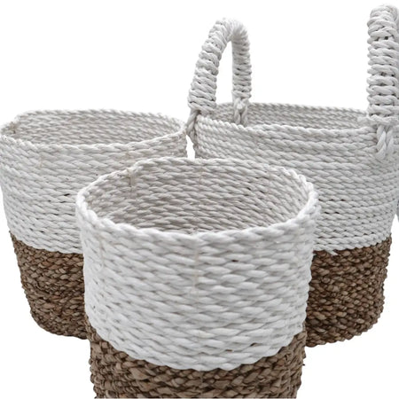 A set of 3 natural and white woven seagrass baskets with braided handles for storage and organization