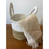 White and beige woven seagrass basket with rope handles part of a natural and white set of 3 baskets