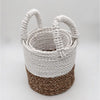 A set of three seagrass baskets with natural brown and white braided design and white rope handles